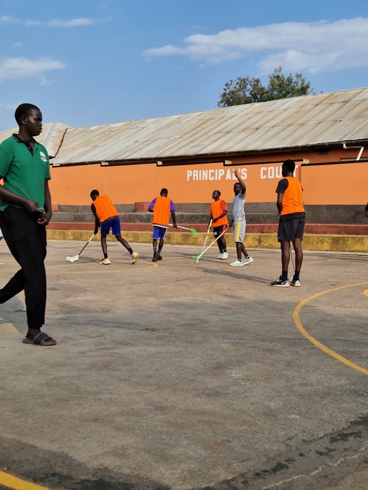 Players running a floorball passing drill