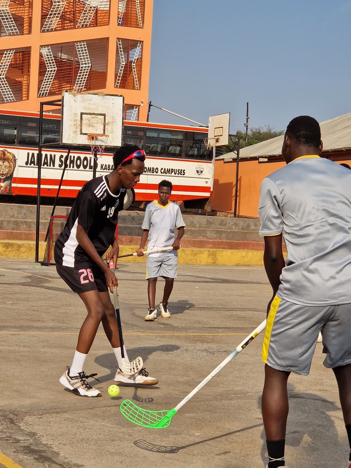 Two players contesting the ball with floorball sticks